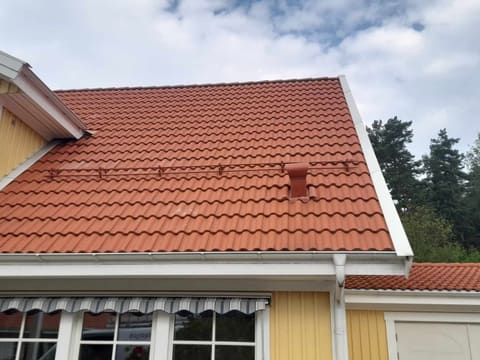 Gult hus med rent, rødt teglsteinstak